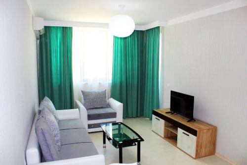 a living room with a couch and a tv at Private apartments Stamopolu lux in Primorsko