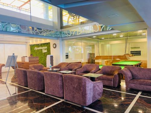 a living room with couches and a pool table at Home2 Renaissance Club in Mumbai