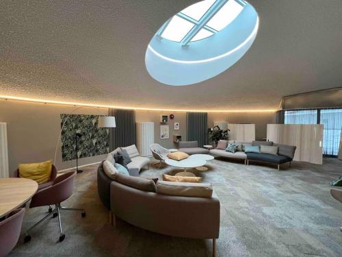 ein großes Wohnzimmer mit Sofas und einer großen Leuchte in der Unterkunft Brand new modern condo built-in Mall of Tripla in Helsinki