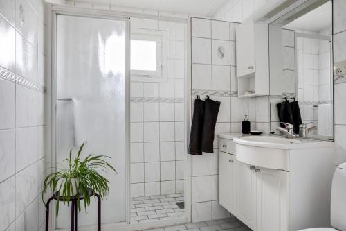 a white bathroom with a shower and a sink at Nice home, where you can feel home at vikingavägen 75 in Gävle