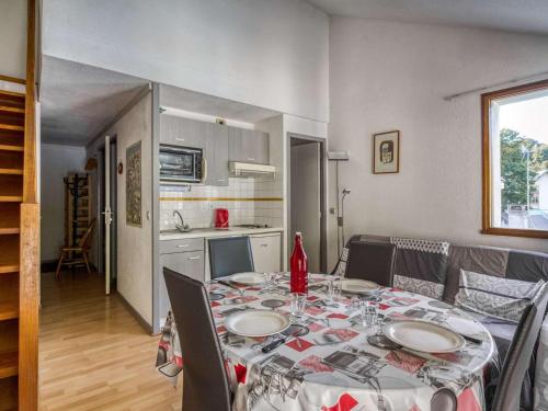 une table de salle à manger avec des chaises et une cuisine dans l'établissement Duplex cosy 6 pers, 2 ch, balcon, parking, près des pistes à Barèges - FR-1-403-9, à Barèges