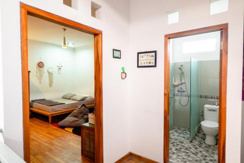 a bathroom with a toilet and a bed in a room at Calda Homestay Syariah in Bandung