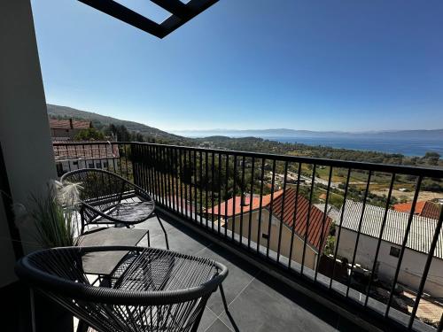 a balcony with two chairs and a view of the ocean at La Vista Luxury Villa in Ohrid