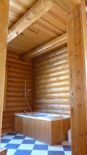 a sauna with a tub in a wooden wall at CHALET DE L'OURS in Saint-Pierre-dels-Forcats