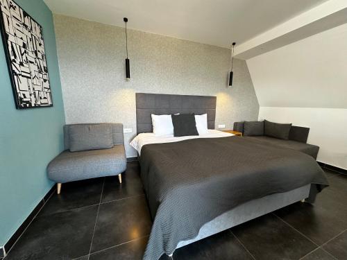 a bedroom with a large bed and a chair at La Vista Luxury Villa in Ohrid