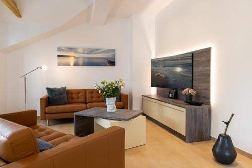a living room with a couch and a television at Villa Beatrice - WE 13 mit eigener Sauna, 2 Dachterrassen, kleiner Meerblick in Binz