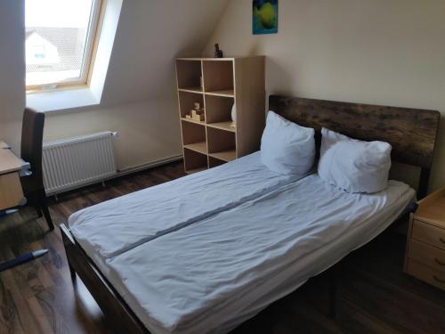 Schlafzimmer mit einem Bett mit weißer Bettwäsche und Kissen in der Unterkunft Modern townhouse, quiet and close to the centre. in Berlin