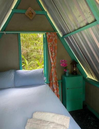 um quarto com uma cama numa tenda com uma janela em Eco Jungle Lodge Juara Tioman em Ilha Tioman