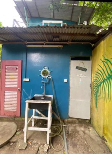 ein blaues Gebäude mit einer Leiter vor einer Tür in der Unterkunft Eco Jungle Lodge Juara Tioman in Tioman Island