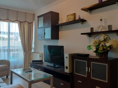 a living room with a television and a table at L&L Livin & Live in Arzúa