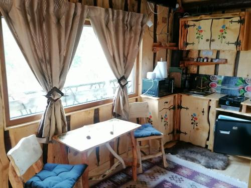 eine Küche mit einem Tisch und einem Fenster in der Unterkunft Casa rustica in Braşov