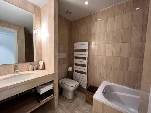 a bathroom with a sink and a toilet and a tub at Super Cannes appartement 40m2, piscines tennis in Vallauris
