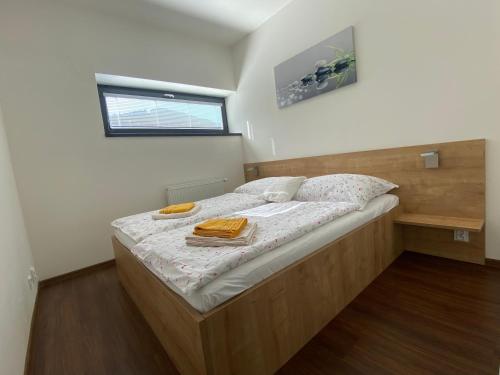 a bedroom with a large bed with a wooden frame at Útulný apartmán u Mumlavských vodopádů in Harrachov