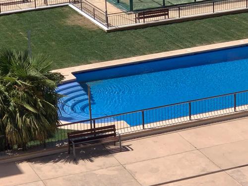 una vista aérea de una piscina con un banco en Atico, Piscina, Aire Acondicionado, WI-FI, Parking Gratis, Gran Terraza en Arroyo de la Encomienda