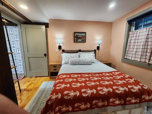 ロックポートにあるThe Orca Suite- Bearskin Neck Rockport- Steps to allの赤いベッドカバーがかかったベッドのある寝室