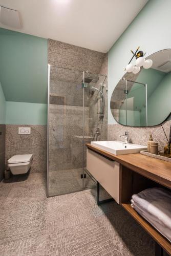 a bathroom with a shower and a sink and a mirror at PALO Borbirtok - Bed and Wine in Paloznak