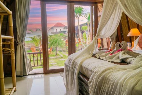a bedroom with a bed with a view of the ocean at Pondok Bali Cottage in Kintamani