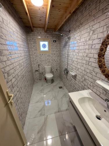 a white bathroom with a toilet and a sink at Beit Tolba in Dahab