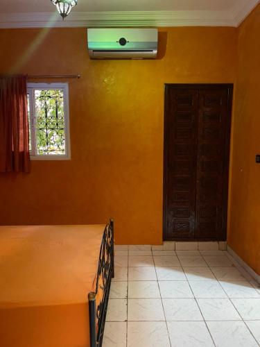 een slaapkamer met een bed, een raam en een deur bij Garden Bloom in Marrakesh