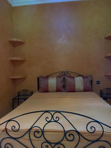 een bed met een metalen hoofdeinde in een slaapkamer bij Garden Bloom in Marrakesh