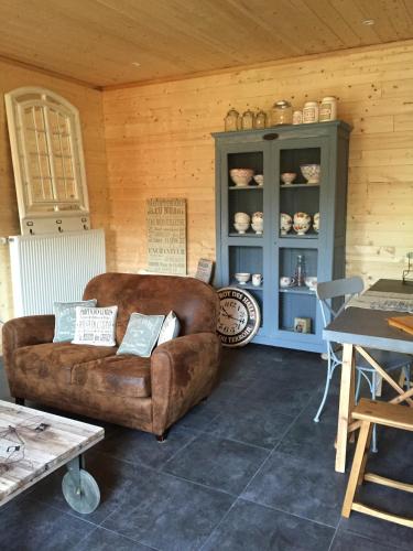 a living room with a brown couch and a blue cabinet at Maison & Tartine in Colombey-les-deux-Églises
