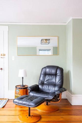 a black leather chair sitting in a room at The Seabird Suite in Marblehead