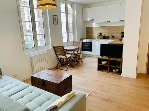 uma sala de estar com um sofá e uma cozinha em Cosy Studio - Verneuil d'Avre et d'Iton em Verneuil d’Avre et d’Iton