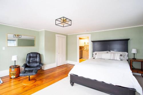 a bedroom with a bed and a black chair at The Seabird Suite in Marblehead