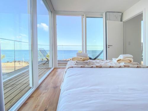 a bedroom with a large bed with a view of the ocean at Pedra do Mar in São Roque