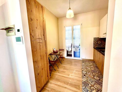 a hallway with a door to a kitchen with a table at Verdura Home in Caltabellotta