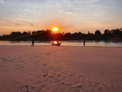 Due persone in piedi su una spiaggia al tramonto di Angkor Bird Nest Resort 