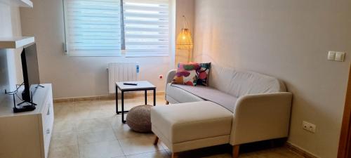 ein Wohnzimmer mit einem Sofa und einem Tisch in der Unterkunft Piso 2 Dormitorios. WIFI in Pontevedra