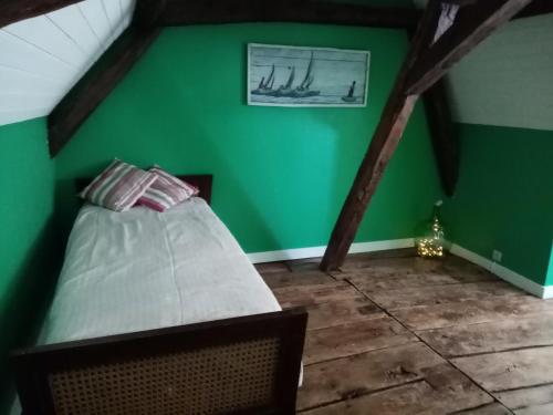 a bedroom with a green wall and a bed at Maison en plein cœur de ville à Montmorillon in Montmorillon