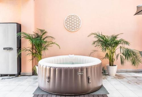a hot tub in a room with two palm trees at Casa Mandala - Con terrazza e jacuzzi in Sesto San Giovanni