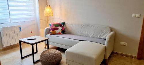 a living room with a white couch and a table at Piso 2 Dormitorios. WIFI in Pontevedra