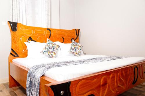 a bedroom with a wooden bed with white sheets and pillows at Sajaairbnb in Narok