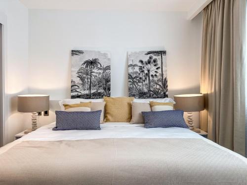 ein Schlafzimmer mit einem großen weißen Bett mit blauen Kissen in der Unterkunft BG2D3 Amazing apartment with private picuzzi in private terrace in Punta Cana