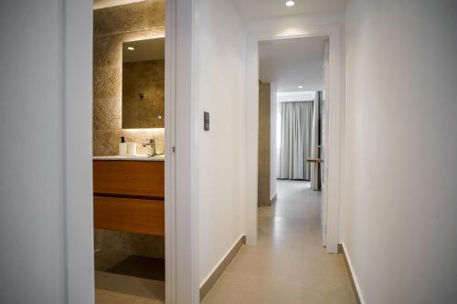 einen Flur, der zu einer Küche mit weißen Wänden führt in der Unterkunft BG2D3 Amazing apartment with private picuzzi in private terrace in Punta Cana