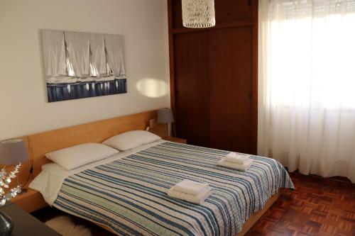 a bedroom with a bed with two towels on it at Sea View Apartment in Faro
