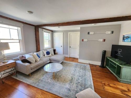 a living room with a couch and a table at Sailors Retreat in Marblehead