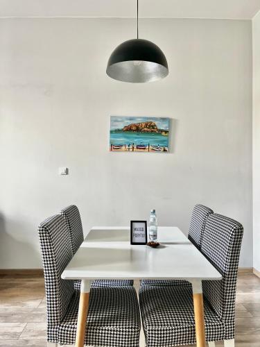 a dining room table with chairs and a black light fixture at The Garbary - parking free in Bydgoszcz