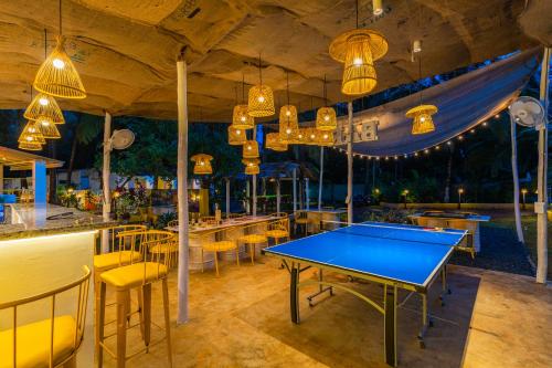a ping pong table and chairs in a restaurant at Whoopers Party Hostel, Palolem in Palolem