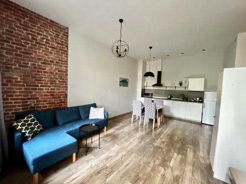 a living room with a blue couch and a brick wall at ACM Centrum Apartament z parkingiem in Bydgoszcz