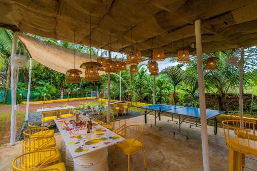 a restaurant with a table and chairs and a table and chairsktop at Whoopers Party Hostel, Palolem in Palolem