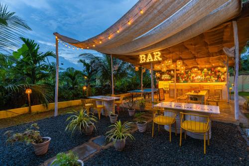 a bar with tables and chairs under a tent at Whoopers Party Hostel, Palolem in Palolem