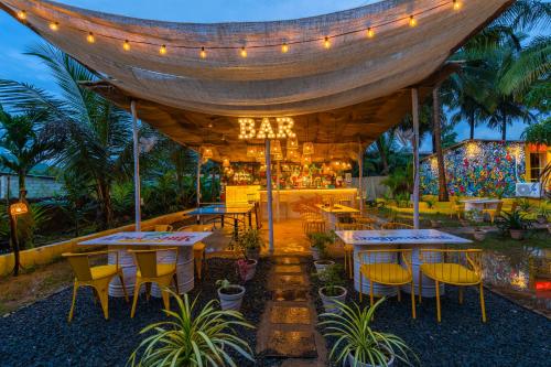 an outdoor restaurant with tables and chairs and lights at Whoopers Party Hostel, Palolem in Palolem