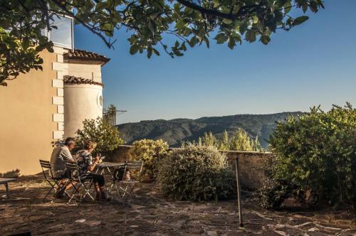 two people sitting at a table in front of a building at Residenza D'epoca Tamara in Castellabate