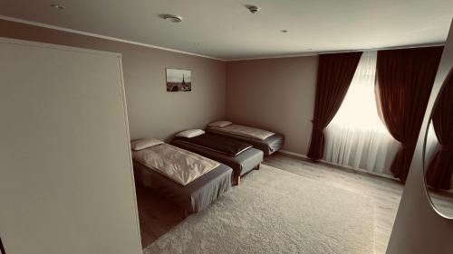 um pequeno quarto com 2 camas e uma janela em Rudnic villa s Ap1 em Syfteland