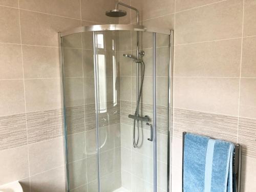 een douche met een glazen deur in de badkamer bij Harrys in Torquay