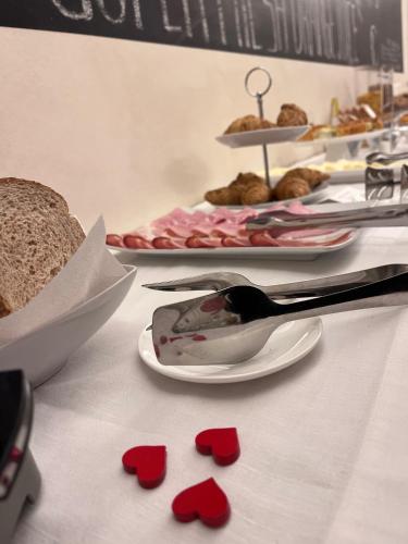 a table with red paper hearts on a table with desserts at Hotel Residenza la Ceramica in Fabriano